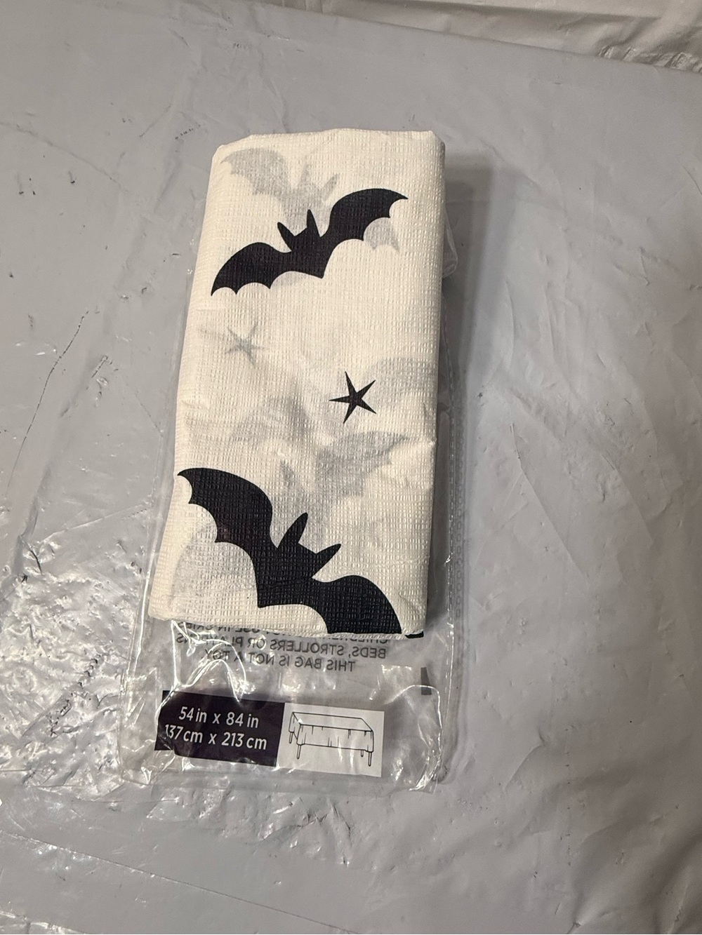 white Halloween tablecloth bat design measuring 54 by 84 inches